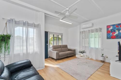 a living room with a couch and a table at Townsville Suites in Townsville