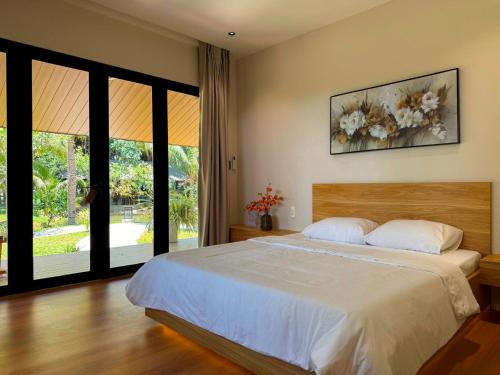 a bedroom with a bed and a large window at Annhien home's in Phan Rang–Tháp Chàm