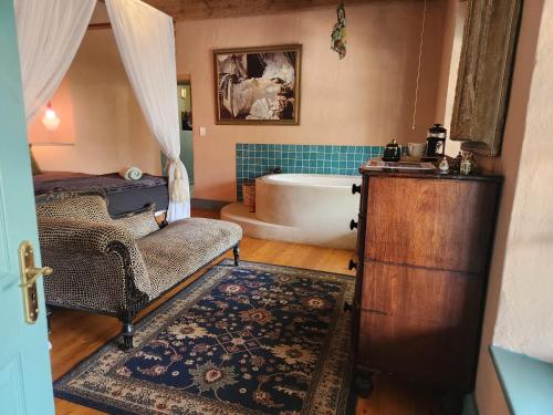 a bathroom with a bath tub and a bed and a chair at Greyton Toad Hall exclusive use up to 18 and by supplement up to 22 with massive pool and hot tub and sometimes we rent individual rooms in Greyton
