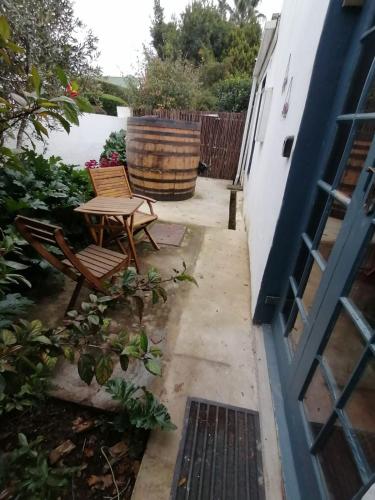 a patio with a table and chairs next to a building at Greyton Toad Hall exclusive use up to 18 and by supplement up to 22 with massive pool and hot tub and sometimes we rent individual rooms in Greyton