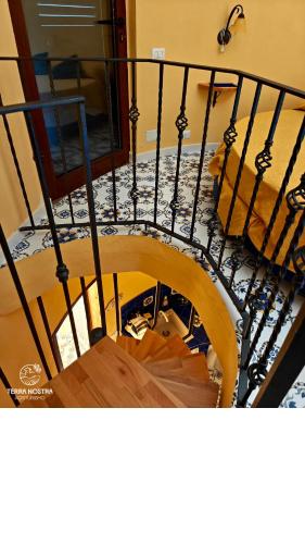 a spiral staircase with black railing in a house at Agriturismo Terra Nostra in San Mauro Cilento