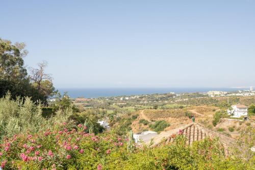 a view of the ocean from a hill with flowers at Grand Villa! with Golf & Sea view!! in Marbella
