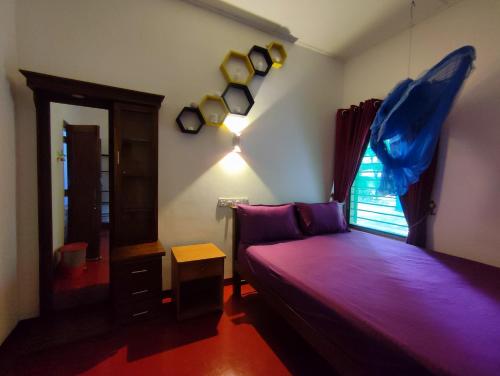 a bedroom with a purple bed and a window at Breeze Guest House in Trincomalee