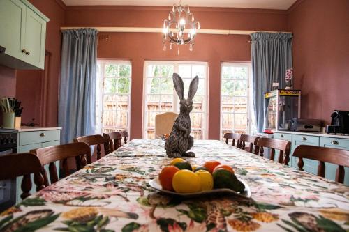 a bunny sitting on a table with a plate of fruit at Greyton Toad Hall exclusive use up to 18 and by supplement up to 22 with massive pool and hot tub and sometimes we rent individual rooms in Greyton