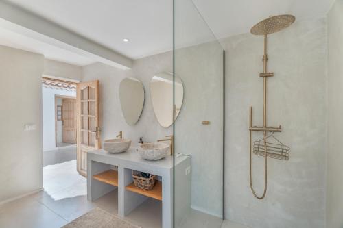 a bathroom with two sinks and mirrors on the wall at Casa Xuixo in Tenerife South in Guía de Isora