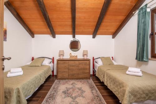 a room with three beds and a wooden ceiling at Villa Ilir in Neum