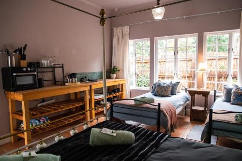 a living room with two beds and a television at Greyton Toad Hall exclusive use up to 18 and by supplement up to 22 with massive pool and hot tub and sometimes we rent individual rooms in Greyton
