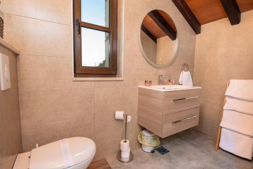 a bathroom with a sink and a toilet and a mirror at Villa Ilir in Neum