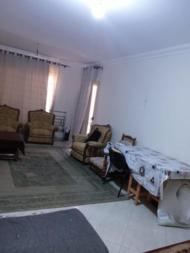 a living room with chairs and a table in it at Pink Horizon Homestay - for Families ONLY in Dumyāţ al Jadīdah