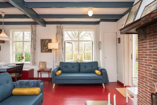 a living room with a blue couch and a table at Vakantiewoning Hosa Semna in de duinen van Vrouwenpolder in Vrouwenpolder