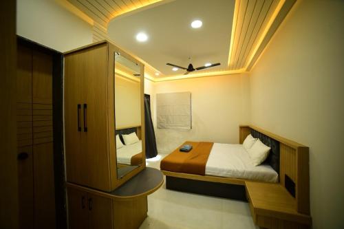a small room with a bed and a mirror at Hotel Highway Nest Igatpuri in Ghoti Budrukh