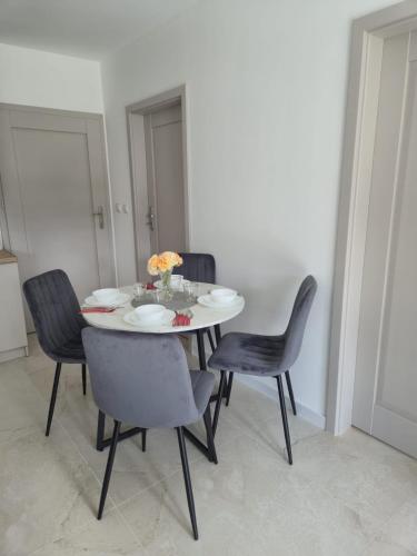 a dining room with a table and chairs at Willa Róż in Rusinowo