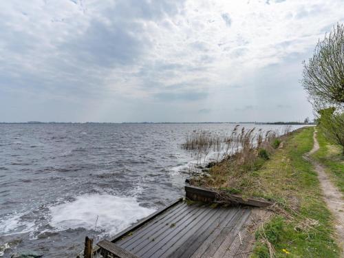 a wooden path next to a body of water at Unique vacation home in Offingawier