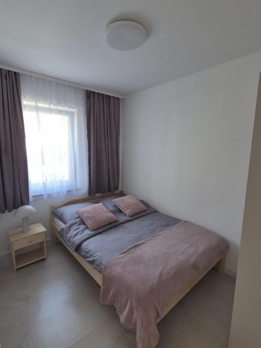 a bed in a bedroom with a window at Willa Róż in Rusinowo
