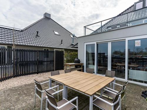 a patio with a wooden table and chairs at Unique vacation home in Offingawier