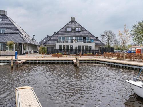 a house with a dock and a boat in the water at Unique vacation home in Offingawier