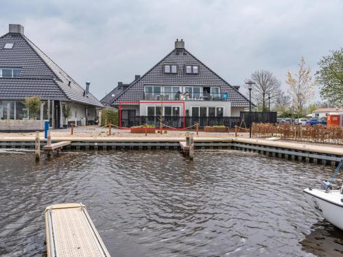 a boat docked at a dock in front of a house at Unique vacation home in Offingawier