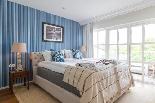 a bedroom with a large bed with blue walls at Ystad Saltsjöbad in Ystad