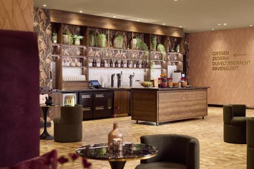 a lobby with a bar with chairs and a table at Van der Valk Hotel Gorinchem-A15 in Gorinchem