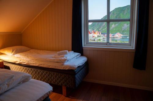 two twin beds in a room with a window at Ballstad Tide House - Lofoten in Ballstad