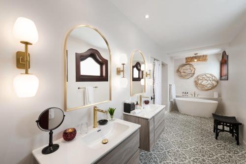 a bathroom with two sinks and a tub and a mirror at Cap Maison Resort & Spa in Cap Estate