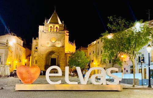 a sign in front of a building with a clock tower at Cozy Apartment Elvas II in Elvas
