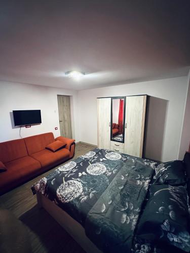 a bedroom with a large bed and a couch at Guest Rooms Comfort 2 City Center in Plovdiv