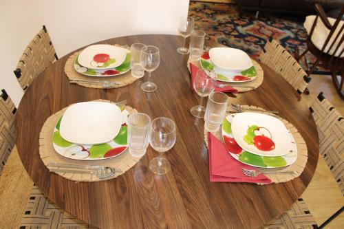 a wooden table with plates and wine glasses on it at Cozy Apartment Elvas II in Elvas