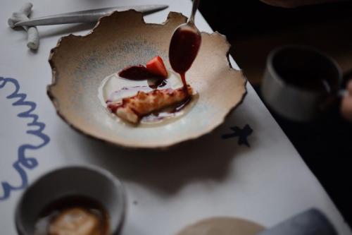 a dessert in a bowl with a spoon on a table at Domaine Saint Clair - Le Donjon in Étretat
