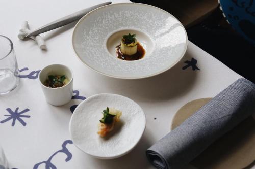 two white plates with food on a table at Domaine Saint Clair - Le Donjon in Étretat