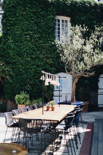 a wooden table with chairs and an umbrella on a patio at Domaine Saint Clair - Le Donjon in Étretat