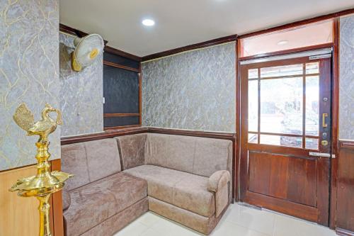 a room with a couch and a window at Hotel O Le Fort in Trivandrum
