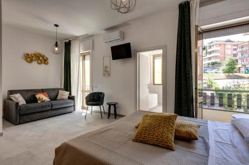 a bedroom with a bed and a couch and a window at Palazzo Belvedere Chianciano Terme in Chianciano Terme