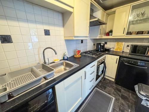 a kitchen with a sink and a dishwasher at Spacious Beautiful London 2 Bedroom Apartment - 2 Bathrooms 1 Parking in London