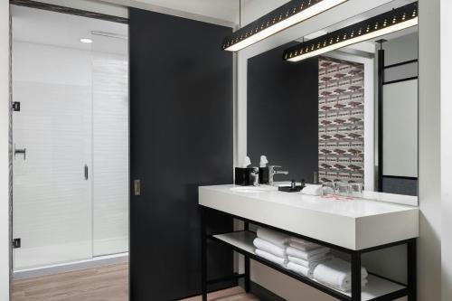 a bathroom with a sink and a mirror at Aloft DFW Airport North in Irving