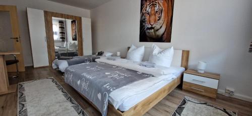 Un dormitorio con dos camas y una imagen de un tigre. en RiGa, en Gera