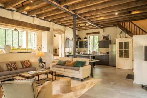 ein Wohnzimmer mit 2 Sofas und einer Küche in der Unterkunft Domaine de Prunget - Pierres d'Histoire in Tendu