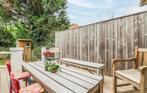 a wooden table with two chairs and a wooden fence at Belle Villa Proche Plage in Bray-Dunes