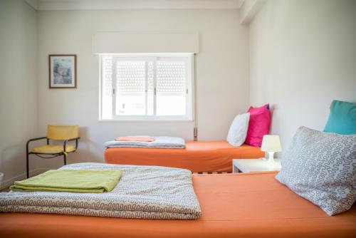 a room with two beds and a window at Alex Point - Guest House in Viana do Castelo
