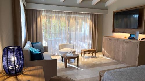 a living room with a couch and a tv at Hotel La Bisaccia in Baja Sardinia