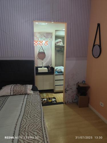 a bedroom with a bed and a door to a closet at Hostel Família Durães in Londrina