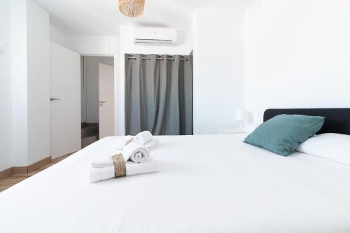 a bedroom with a white bed with towels on it at Global Properties, Deslumbrante casa en la playa de Sagunto in Sagunto
