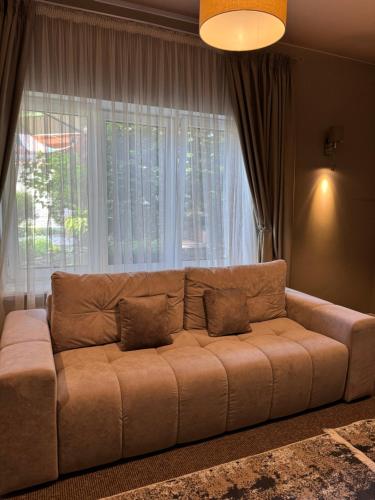 a couch in a living room with a large window at Villa-Sofia Mini-hotel in Odesa