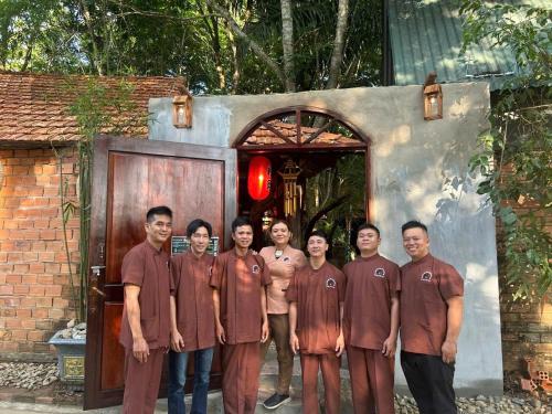 a group of people standing in front of a door at Green Bamboo Lodge Resort in Cat Tien