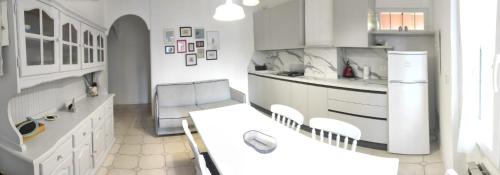a kitchen with white cabinets and a table and chairs at Holiday in Pietra Ligure in Pietra Ligure