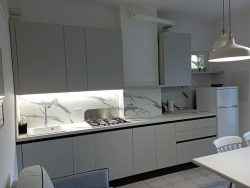 a white kitchen with white cabinets and a sink at Holiday in Pietra Ligure in Pietra Ligure