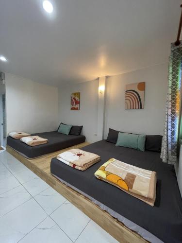 two beds sitting in a room with at The KN Kohlarn in Ko Larn