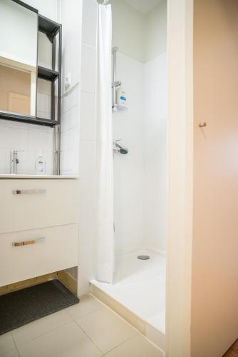 a white bathroom with a shower and a sink at Alex Point - Guest House in Viana do Castelo