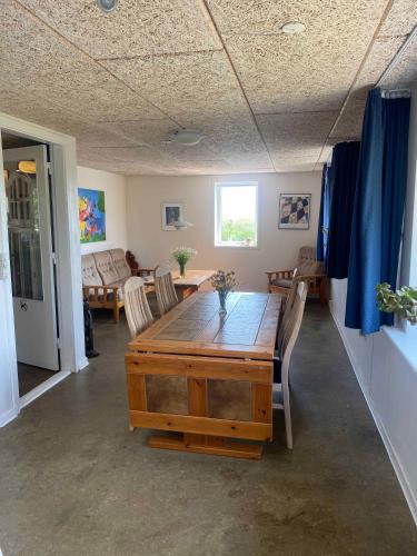 a living room with a wooden table and chairs at Spacious Holiday Home With Views Over Limfjorden in Jørsby