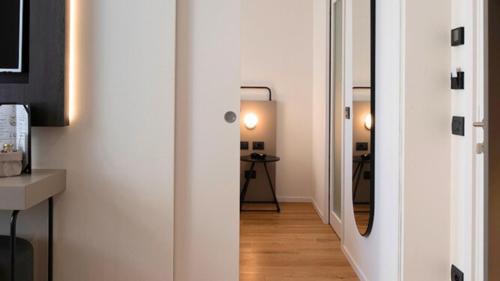 a hallway with white walls and a mirror at I Portici Hotel Bologna in Bologna
